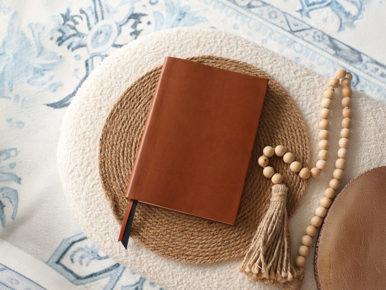 Brown leather notebook on a textured surface with decorative elements